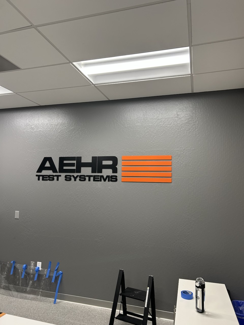 Dimensional company logo sign mounted on an office wall