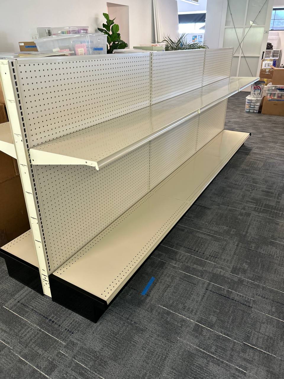 Double-sided retail gondola shelving assembled in a workspace